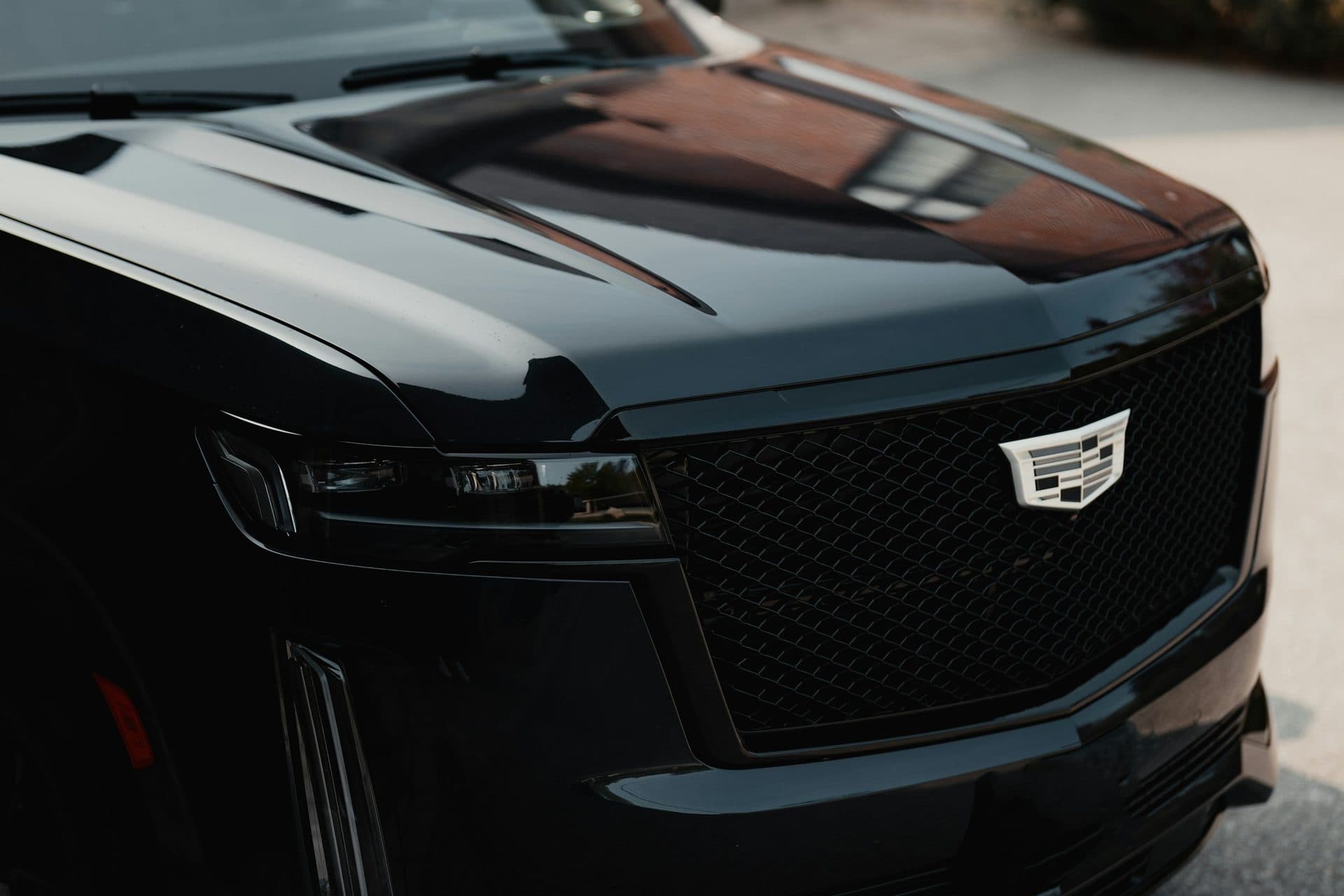 Close-up of the front grille and headlights of a black Cadillac Escalade